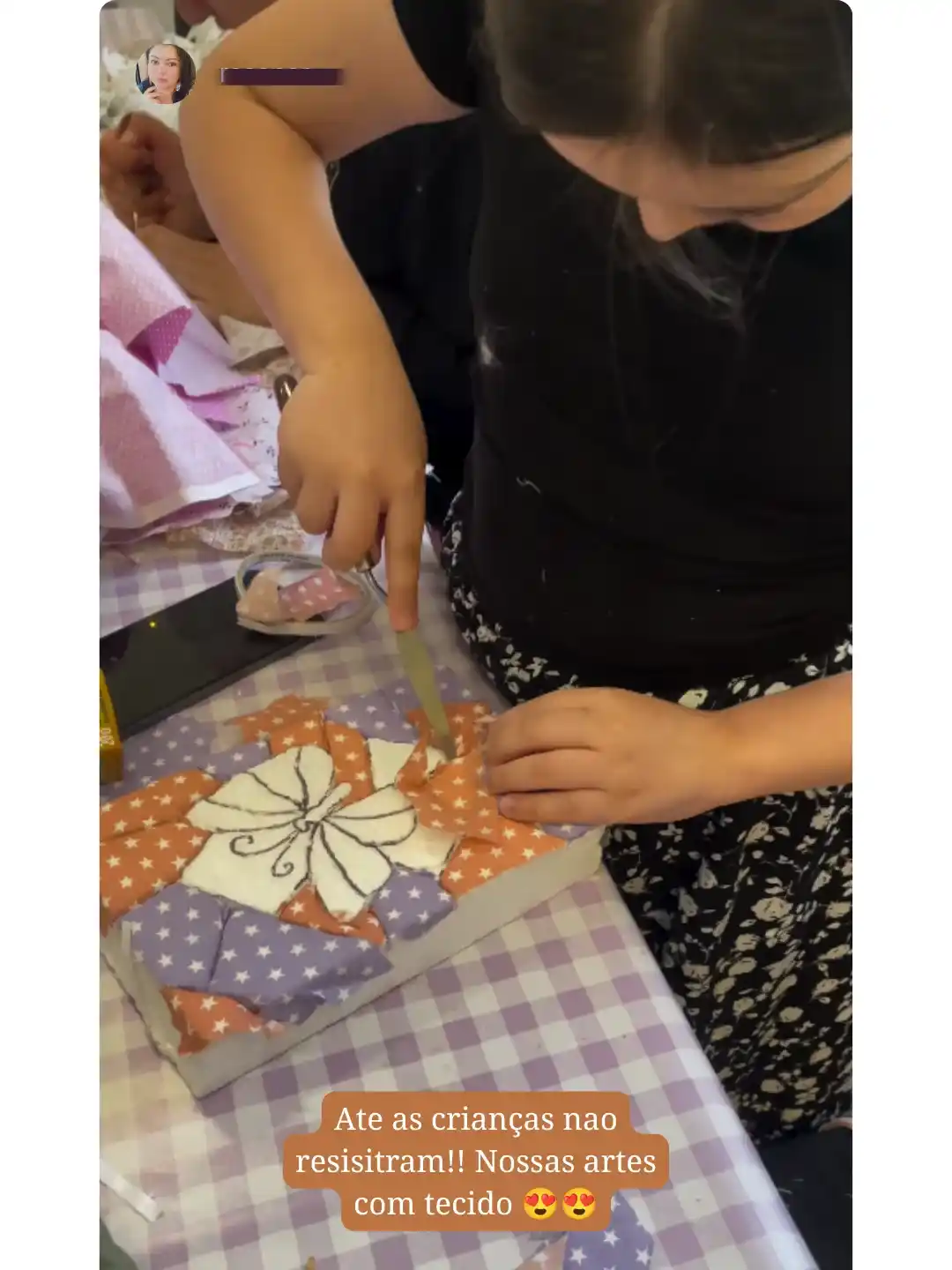 Criança montando arte com tecidos